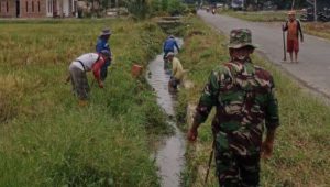 Karya Bakti TNI, Babinsa Koramil Larompong Bersihkan Saluran Air