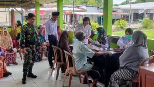 Babinsa Koramil Bone-bone Dampingi Pemeriksaan Kesehatan dan Penyaluran Bantuan Pangan Warganya